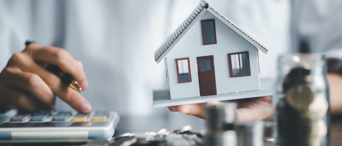 Person berechnet mithilfe eines Taschenrechners die Baufinanzierung