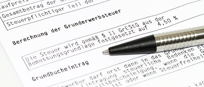 Blatt mit Informationen zur Grunderwerbsteuer und zum Grundbucheintrag