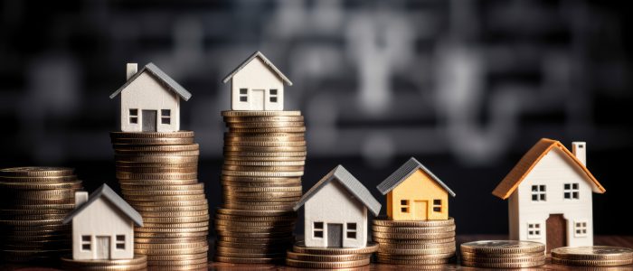 Mehrere Modellhäuser stehen auf Geldmünzen