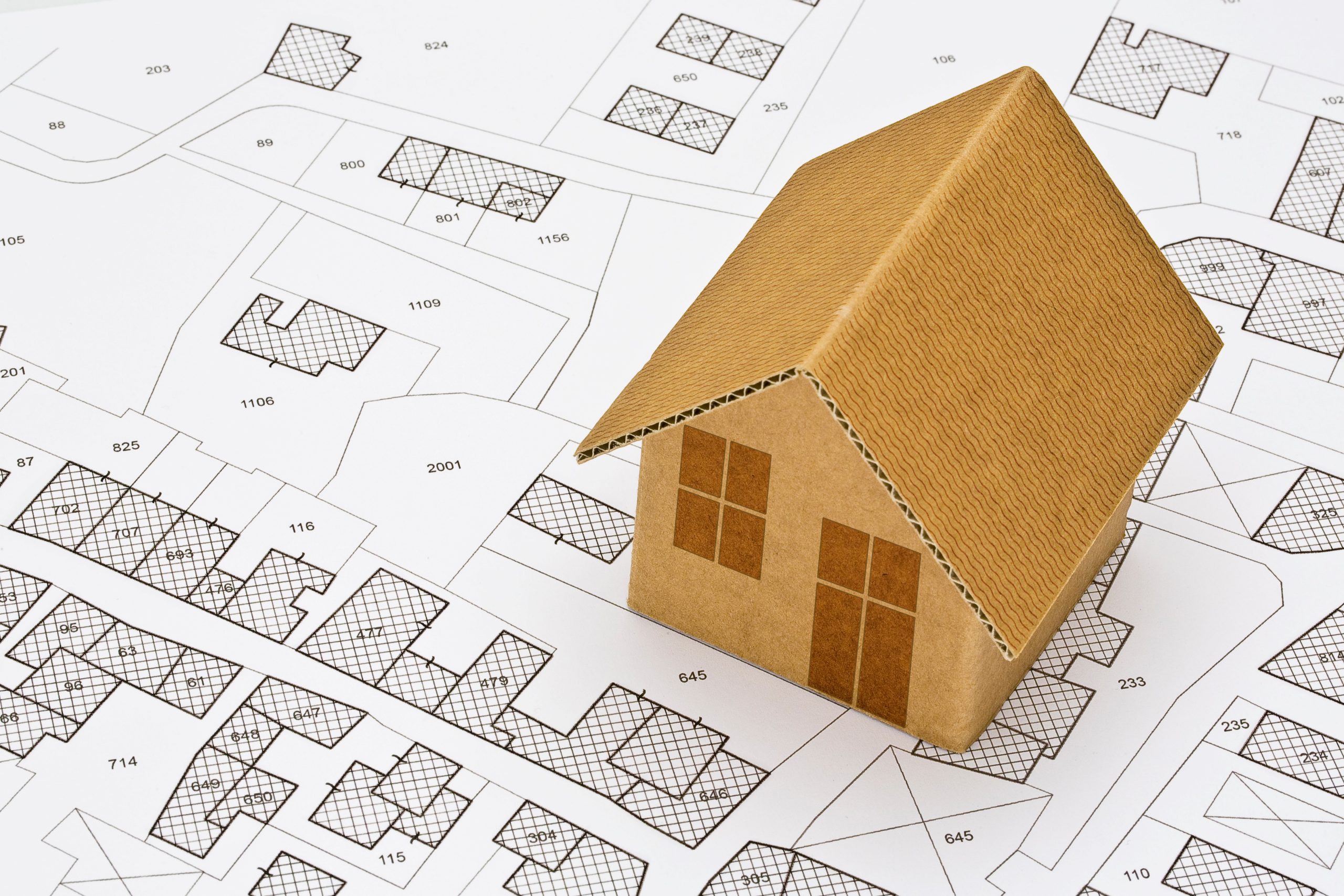 ein Bebauungsplan mit einem Modellhaus aus Pappe