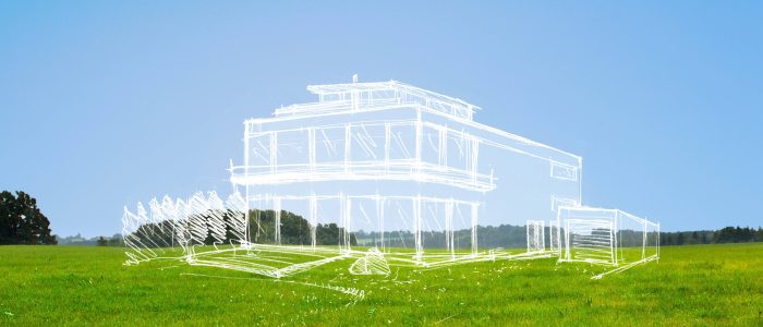 Ein unbebautes Bauland mit der Zeichnung eines Traumhauses darauf