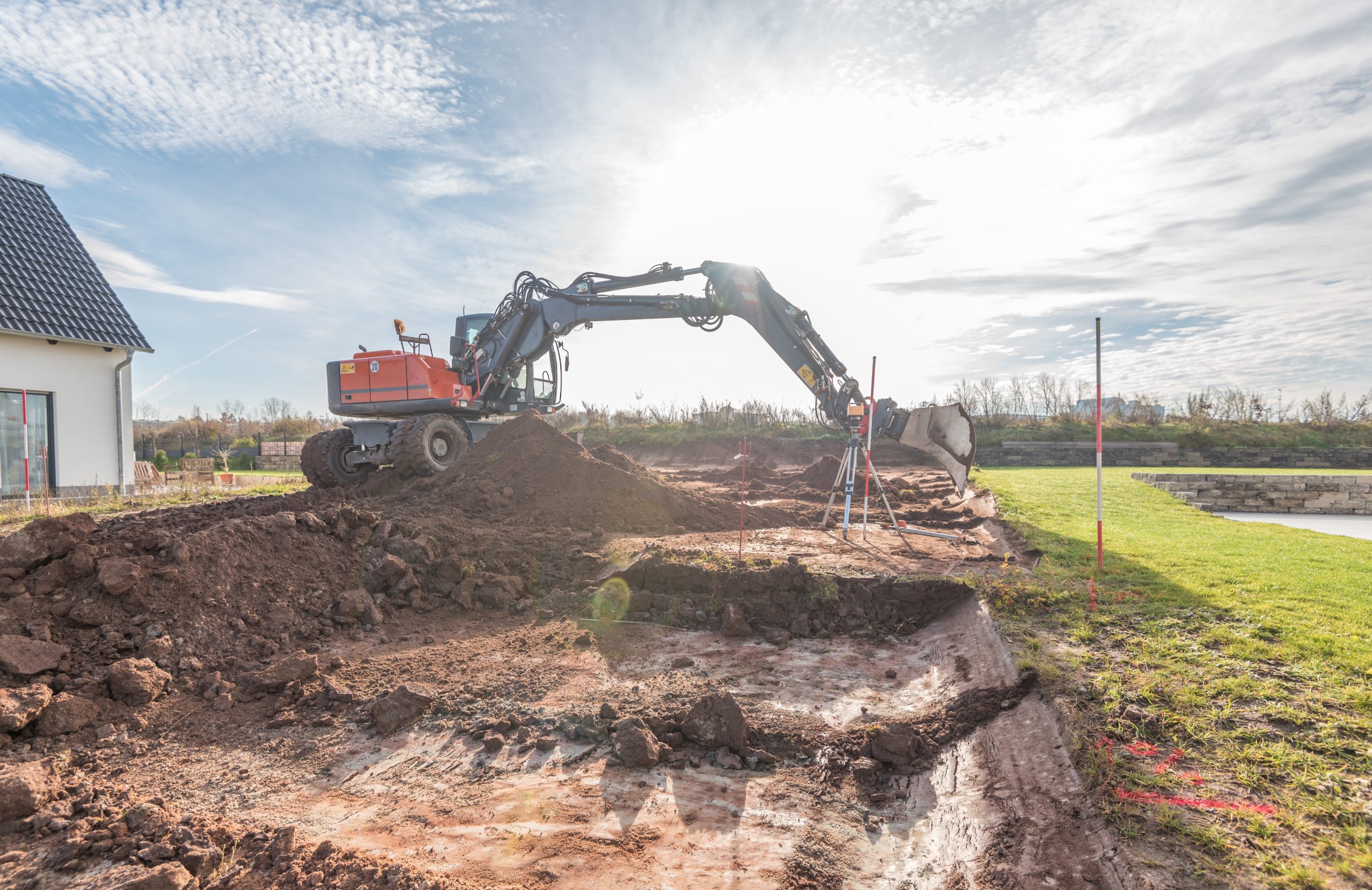 Bagger hebt Erde für die Erschließung eines Baugrundstücks